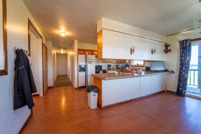 15608 Lawrence Unit 2007, Miller, MO 65707 - kitchen with white fridge with ice dispenser, a peninsula, light wood-type flooring, and brown cabinetry