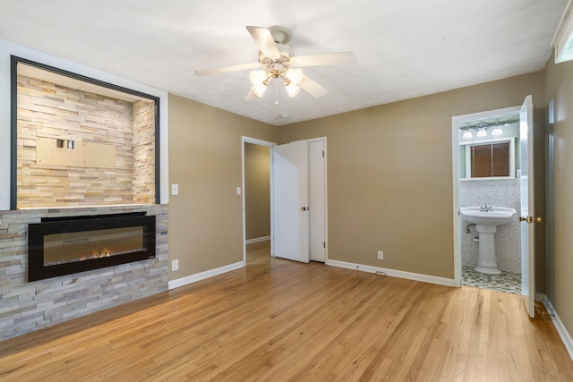 1722 S Link Ave, Springfield, MO 65804 - unfurnished bedroom featuring light wood-style flooring, a fireplace, ensuite bath, and a ceiling fan