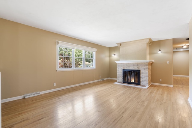 1722 S Link Ave, Springfield, MO 65804 - unfurnished living room featuring a fireplace and light wood-style flooring