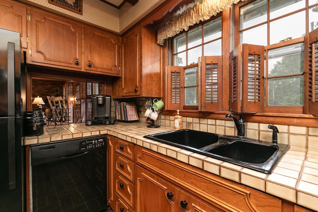 610 W Summit St, Bolivar, MO 65613 - kitchen with black appliances, tile counters, brown cabinetry, and backsplash