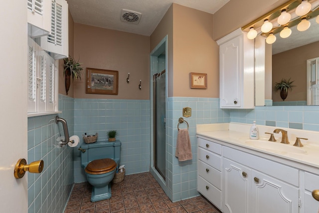 610 W Summit St, Bolivar, MO 65613 - bathroom featuring tile walls, vanity, tile patterned floors, a stall shower, and wainscoting