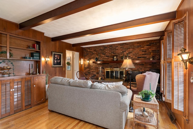 610 W Summit St, Bolivar, MO 65613 - living area with a fireplace, hardwood / wood-style flooring, beam ceiling, and wood walls