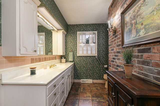 610 W Summit St, Bolivar, MO 65613 - bathroom with wallpapered walls, vanity, and stone finish flooring