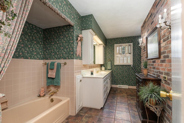 610 W Summit St, Bolivar, MO 65613 - bathroom featuring wallpapered walls, vanity, a bath, wainscoting, and stone finish flooring