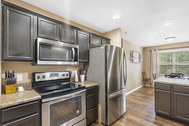 241 Everett Ml Rd, Branson, MO 65616 - kitchen with stainless steel appliances, wood finished floors, light countertops, dark brown cabinetry, and recessed lighting