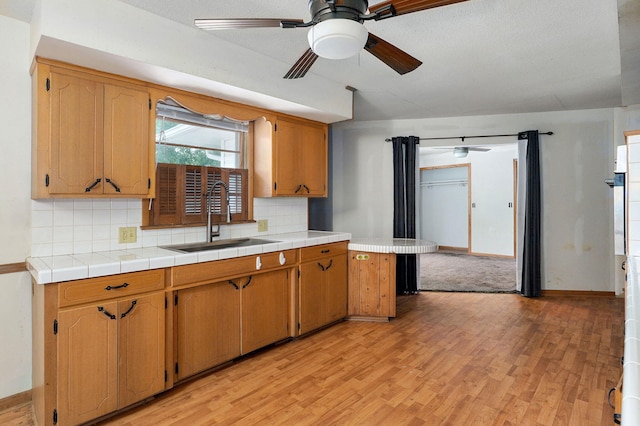 1415 S Sieger Dr, Springfield, MO 65804 - kitchen featuring a ceiling fan, light wood-type flooring, backsplash, and light countertops