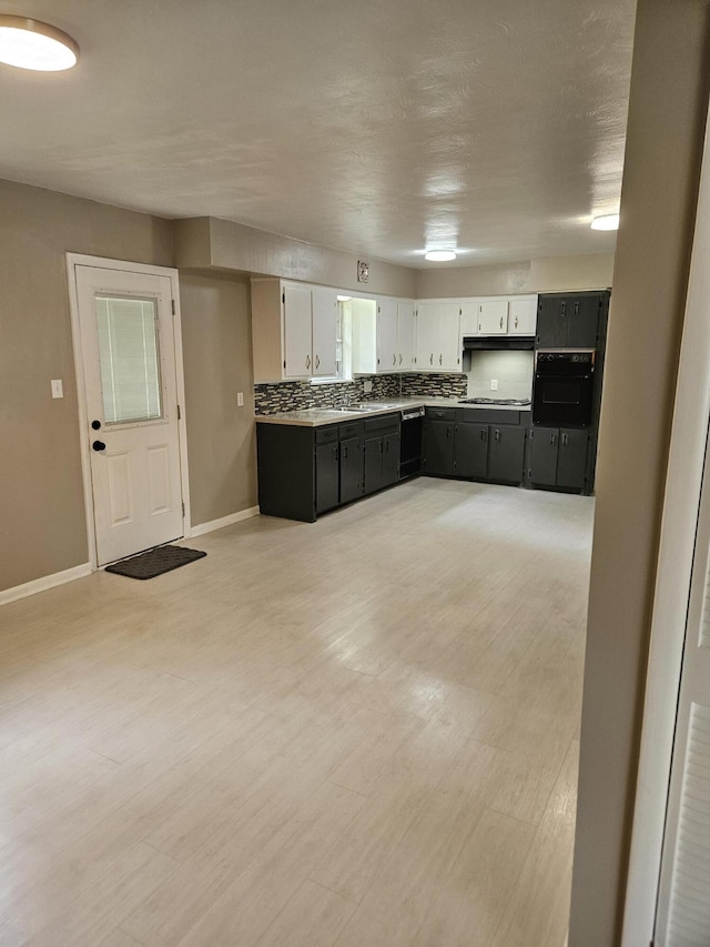 1955 S Fort Ave, Springfield, MO 65807 - kitchen featuring black appliances, decorative backsplash, white cabinetry, light countertops, and light wood finished floors