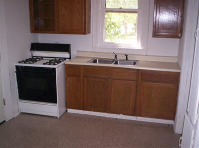 447 S New, Springfield, MO 65806 - kitchen featuring white gas range, light countertops, and brown cabinets