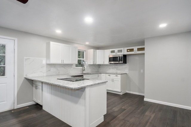 4852 S Fremont Ave, Springfield, MO 65804 - kitchen with stainless steel microwave, a peninsula, black electric stovetop, white cabinetry, and recessed lighting