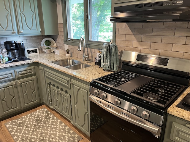 508 E Kirkwood Dr, Aurora, MO 65605 - kitchen featuring gas range, ventilation hood, decorative backsplash, and light stone counters
