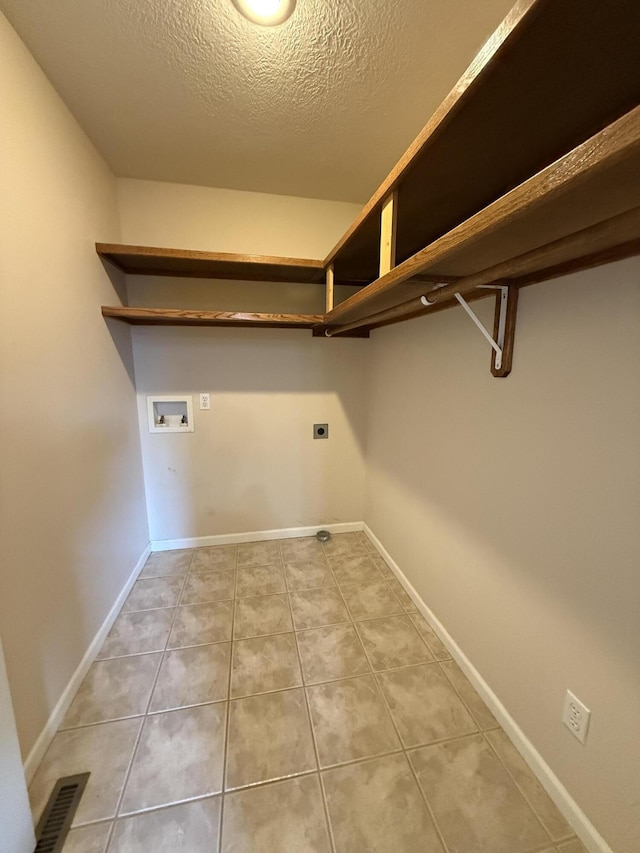 5218 S Gary Ct, Springfield, MO 65810 - laundry room featuring hookup for a washing machine, electric dryer hookup, tile patterned floors, and a textured ceiling