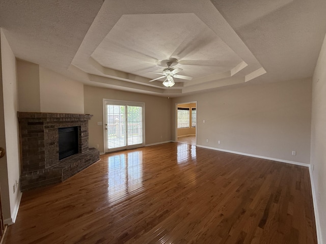 5218 S Gary Ct, Springfield, MO 65810 - unfurnished living room featuring a raised ceiling, wood finished floors, a ceiling fan, a fireplace, and a textured ceiling