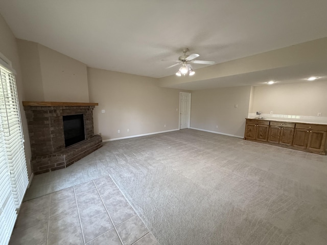 5218 S Gary Ct, Springfield, MO 65810 - unfurnished living room featuring light colored carpet, ceiling fan, a brick fireplace, and light tile patterned floors