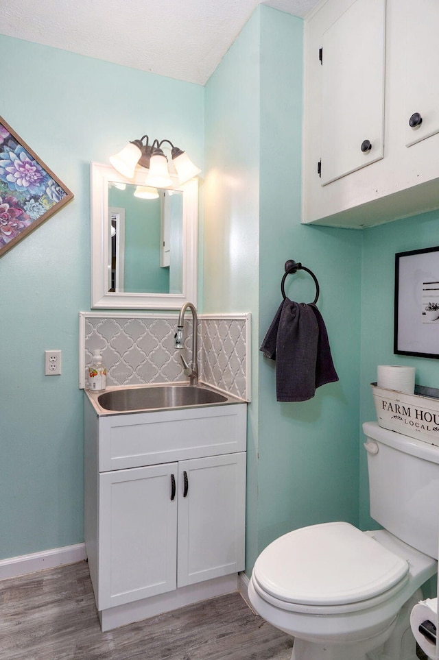 3449 N Rogers Ave, Springfield, MO 65803 - bathroom with decorative backsplash, wood finished floors, and vanity