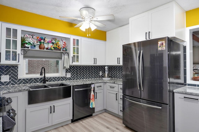 3449 N Rogers Ave, Springfield, MO 65803 - kitchen with freestanding refrigerator, dishwashing machine, a ceiling fan, light wood-style flooring, and tasteful backsplash