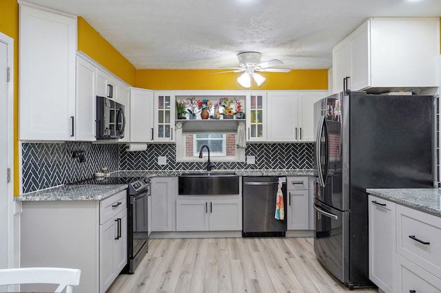 3449 N Rogers Ave, Springfield, MO 65803 - kitchen featuring black appliances, a ceiling fan, light wood finished floors, glass insert cabinets, and white cabinetry