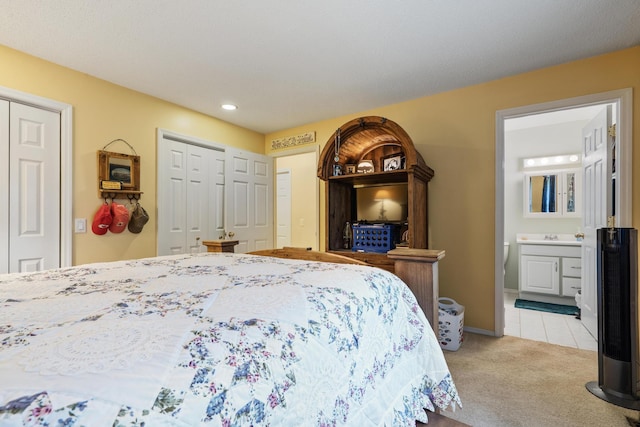 781 Santana Cir, Reeds Spring, MO 65737 - bedroom with light carpet, two closets, recessed lighting, ensuite bathroom, and light tile patterned floors