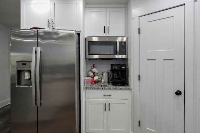 1611 E Hayloft Dr, Ozark, MO 65721 - kitchen with stainless steel appliances, white cabinets, light stone counters, and tasteful backsplash