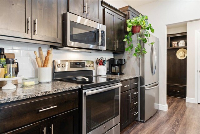 1651 N Penrose Ave, Nixa, MO 65714 - kitchen featuring stainless steel appliances, dark wood-type flooring, decorative backsplash, dark brown cabinetry, and light stone countertops