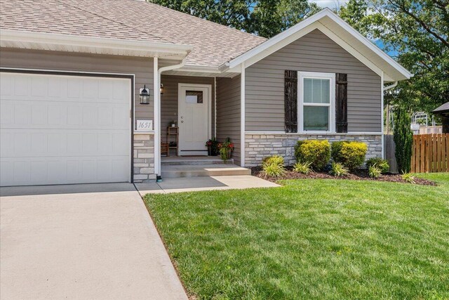 1651 N Penrose Ave, Nixa, MO 65714 - view of front of house featuring stone siding, roof with shingles, an attached garage, and driveway