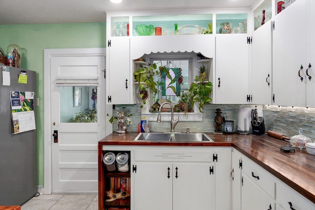 223 E Mill St, Republic, MO 65738 - kitchen with freestanding refrigerator, tasteful backsplash, water heater, and light tile patterned floors