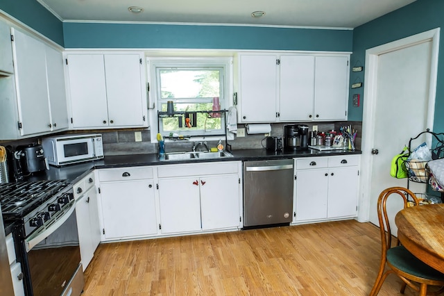 343 N Wood Ln, Fair Grove, MO 65648 - kitchen featuring appliances with stainless steel finishes, backsplash, dark countertops, light wood-type flooring, and crown molding