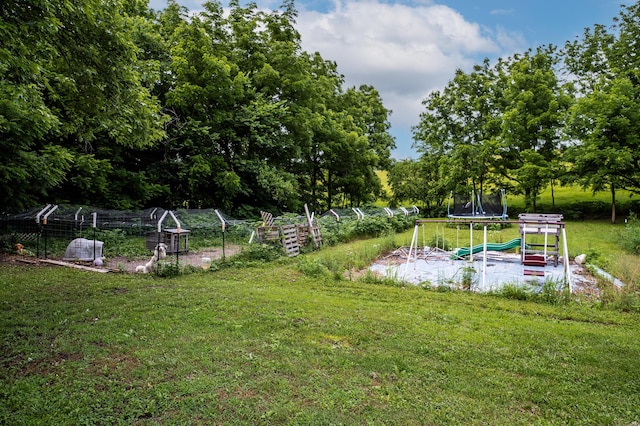 343 N Wood Ln, Fair Grove, MO 65648 - view of green lawn featuring a trampoline, a vegetable garden, and view of wooded area