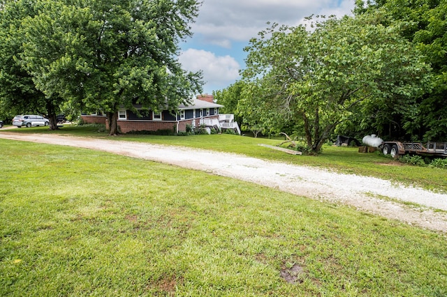 343 N Wood Ln, Fair Grove, MO 65648 - view of front facade featuring driveway, a front lawn, brick siding, and a chimney