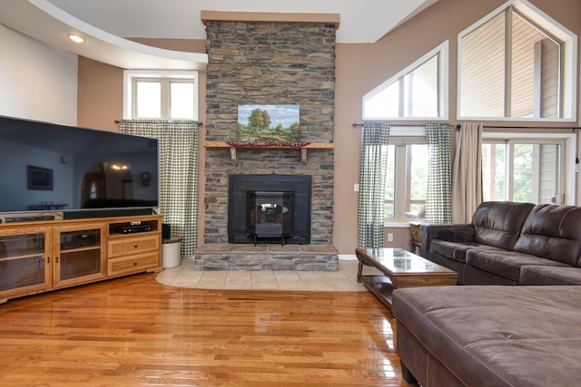 112 Silver Oak Way, Branson West, MO 65737 - living area featuring light wood finished floors, healthy amount of natural light, a towering ceiling, and a wood stove