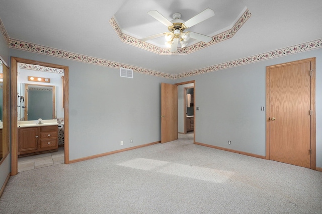 131 Forest Ln, Kimberling City, MO 65686 - unfurnished bedroom featuring carpet floors, a raised ceiling, ensuite bathroom, and a ceiling fan