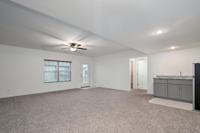 842 E Acacia Ln, Nixa, MO 65714 - unfurnished living room with light colored carpet, a ceiling fan, bar with sink, and recessed lighting