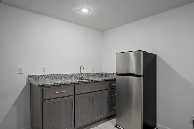 842 E Acacia Ln, Nixa, MO 65714 - kitchen featuring freestanding refrigerator, light marble finish flooring, dark stone counters, and recessed lighting