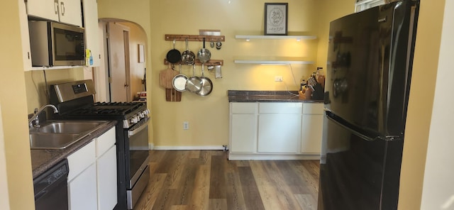 1972 N Colgate Ave, Springfield, MO 65802 - kitchen with black appliances, arched walkways, white cabinets, and dark wood-style flooring
