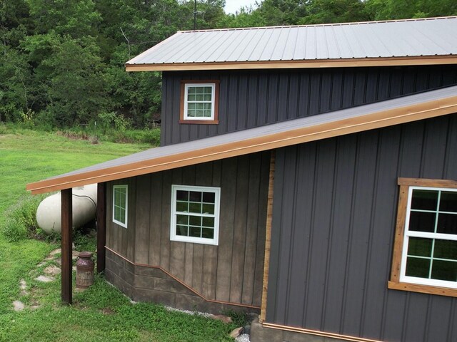 200 NE 90th Ln, Lamar, MO 64759 - view of home's exterior with a metal roof, a yard, and board and batten siding