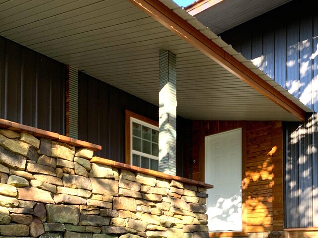 200 NE 90th Ln, Lamar, MO 64759 - doorway to property with stone siding, a porch, and board and batten siding