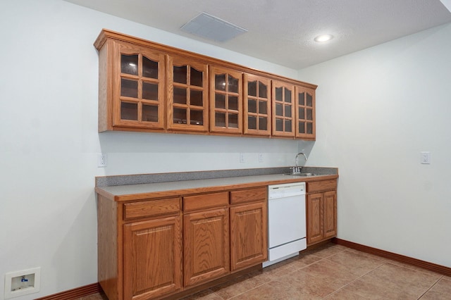4520 English Ivy Ave, Springfield, MO 65804 - kitchen featuring dishwasher, brown cabinetry, glass insert cabinets, recessed lighting, and light tile patterned floors