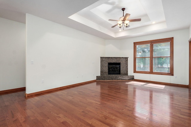 4520 English Ivy Ave, Springfield, MO 65804 - unfurnished living room featuring a tray ceiling, a ceiling fan, wood finished floors, a high end fireplace, and recessed lighting