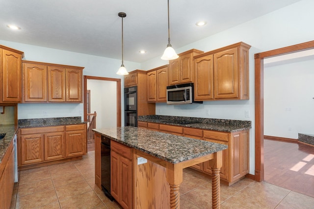 4520 English Ivy Ave, Springfield, MO 65804 - kitchen with stainless steel microwave, hanging light fixtures, brown cabinetry, dark stone counters, and recessed lighting