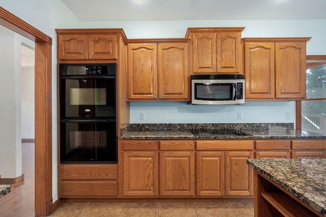 4520 English Ivy Ave, Springfield, MO 65804 - kitchen featuring black appliances, dark stone countertops, brown cabinets, and light tile patterned floors