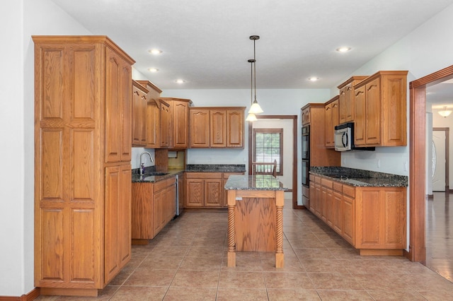 4520 English Ivy Ave, Springfield, MO 65804 - kitchen with brown cabinets, a kitchen island, dark stone counters, stainless steel appliances, and recessed lighting