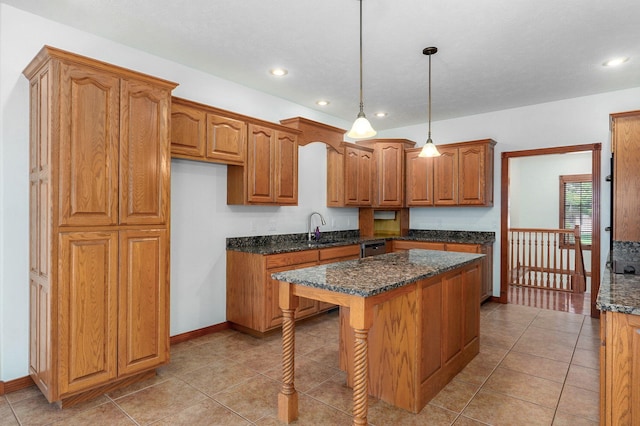 4520 English Ivy Ave, Springfield, MO 65804 - kitchen featuring brown cabinetry, dark stone countertops, a center island, decorative light fixtures, and recessed lighting