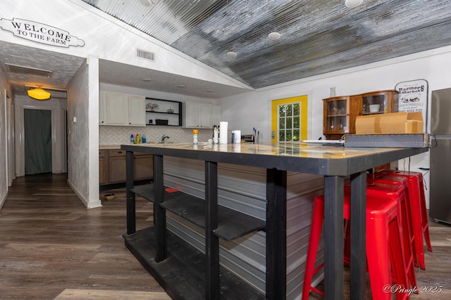 3331 US Highway 160, West Plains, MO 65775 - kitchen with vaulted ceiling, open shelves, dark wood finished floors, decorative backsplash, and a kitchen bar
