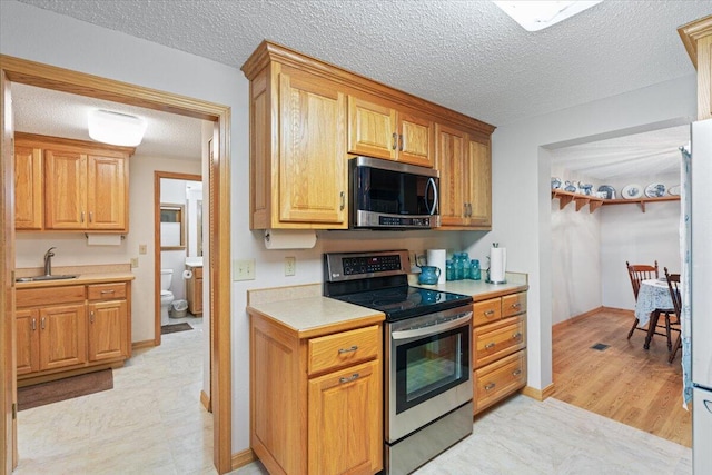 112 Riverview Dr, Anderson, MO 64831 - kitchen with appliances with stainless steel finishes, light countertops, and a textured ceiling