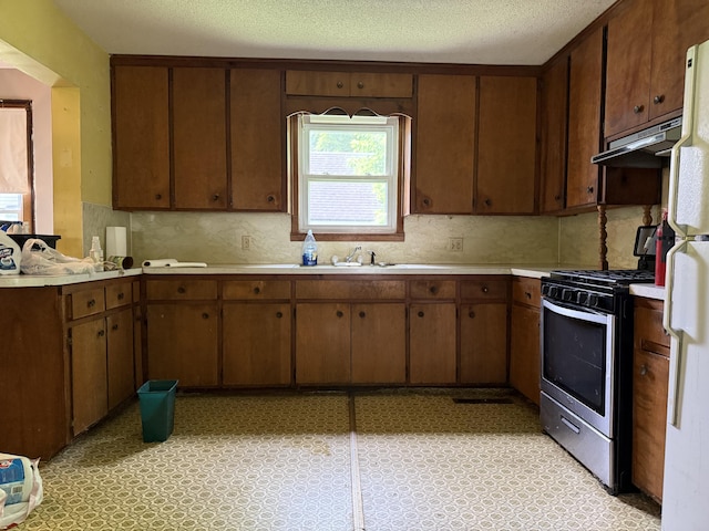 405 N Walnut St, Pierce City, MO 65723 - kitchen with stainless steel gas stove, light countertops, decorative backsplash, a peninsula, and freestanding refrigerator