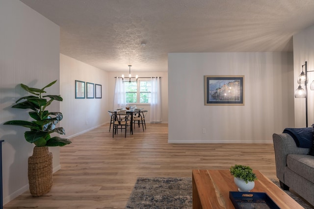 2443 S Kickapoo Ave, Springfield, MO 65804 - living area with a chandelier, light wood-style floors, and a textured ceiling