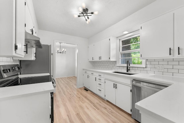 2443 S Kickapoo Ave, Springfield, MO 65804 - kitchen featuring a chandelier, stainless steel appliances, under cabinet range hood, white cabinets, and tasteful backsplash