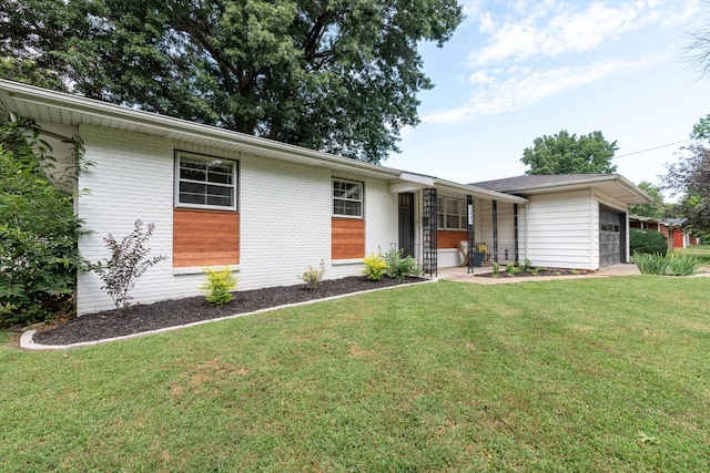 2443 S Kickapoo Ave, Springfield, MO 65804 - view of front facade featuring a front lawn, a garage, brick siding, and covered porch