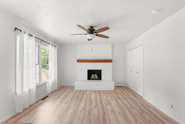 2443 S Kickapoo Ave, Springfield, MO 65804 - unfurnished living room with light wood-style floors, ceiling fan, and a fireplace