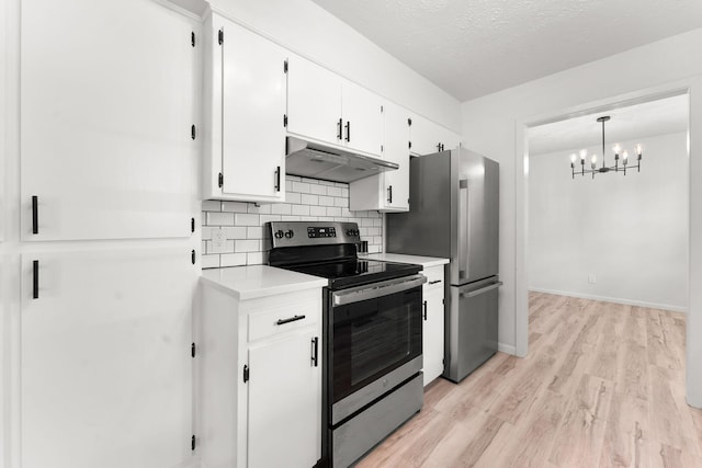 2443 S Kickapoo Ave, Springfield, MO 65804 - kitchen featuring stainless steel appliances, under cabinet range hood, light wood-type flooring, backsplash, and a chandelier