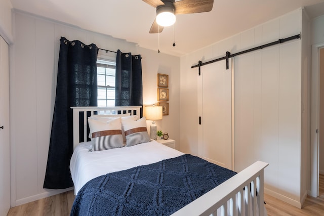 2443 S Kickapoo Ave, Springfield, MO 65804 - bedroom featuring a barn door and light wood-type flooring